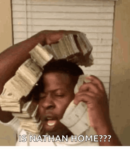 A Man Is Talking On A Cell Phone While Holding A Stack Of Money On Top Of His Head . GIF