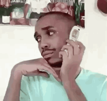 A Man Is Talking On A Cell Phone While Sitting Down . GIF