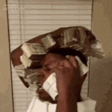 a man is talking on a cell phone while wearing a hat made of money .
