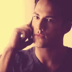 a man is talking on a cell phone with his hand on his face