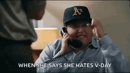 A Man Is Talking On A Phone While Wearing A Hat . GIF
