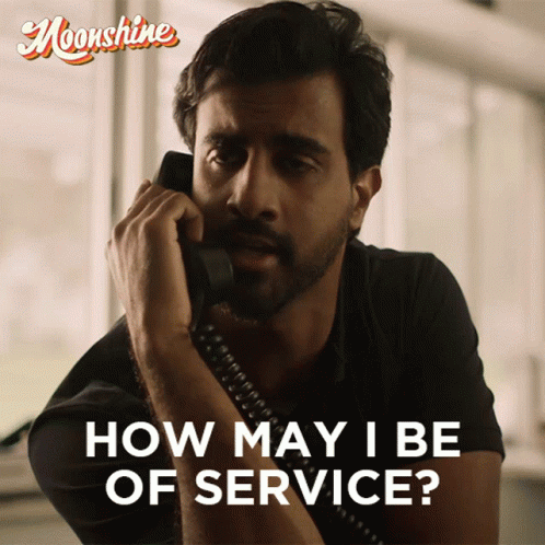 A Man Is Talking On A Phone With The Words How May I Be Of Service GIF