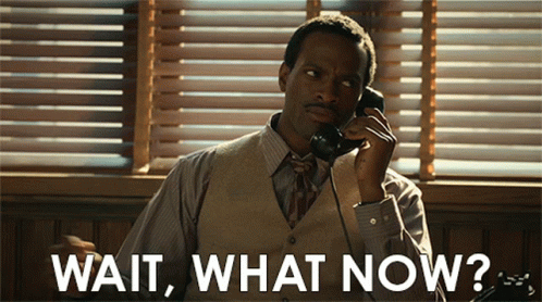 A Man Is Talking On A Phone With The Words Wait What Now Written Below Him GIF