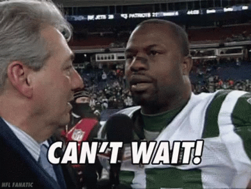 A Man Is Talking To A Football Player Who Is Wearing A Green And White Uniform . GIF