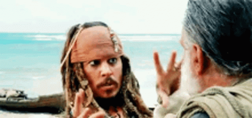 A Man Is Talking To A Man On A Beach . GIF