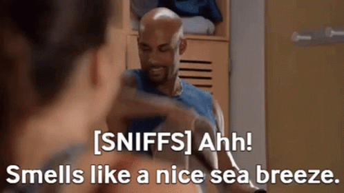 A Man Is Talking To A Woman In A Locker Room And The Woman Is Smelling Like A Nice Sea Breeze GIF