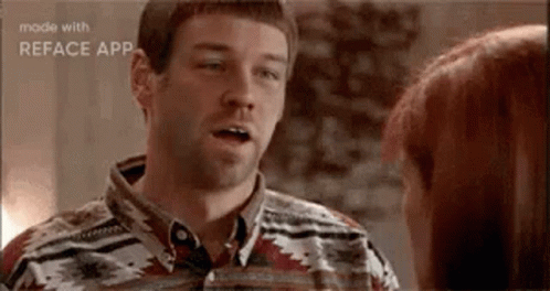A Man Is Talking To A Woman In A Room . GIF