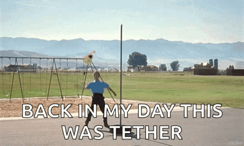 A Man Is Throwing A Frisbee In A Field With The Words " Back In My Day This Was Tether " On The Bottom GIF