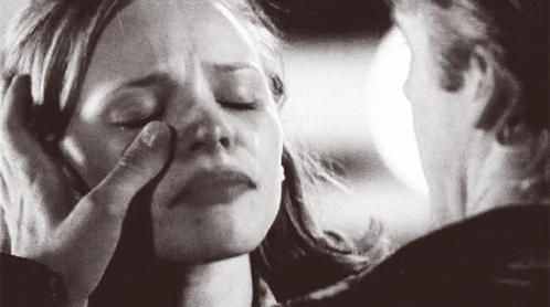 A Man Is Touching A Woman 'S Face With His Hand . GIF