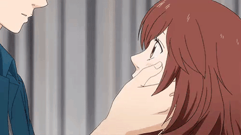 A Man Is Touching A Woman 'S Face With His Hand While They Are Looking At Each Other . GIF