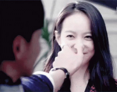 A Man Is Touching A Woman 'S Nose While She Smiles GIF