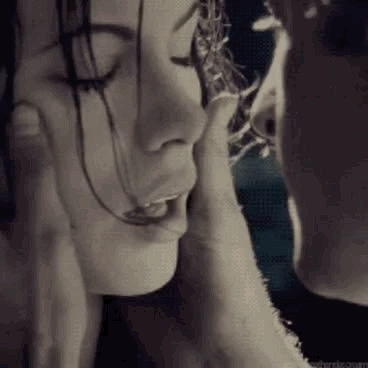A Man Is Touching The Face Of A Woman In A Black And White Photo . GIF