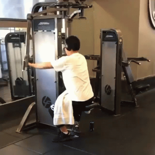A Man Is Using A Machine With The Word Life Fitness On It GIF