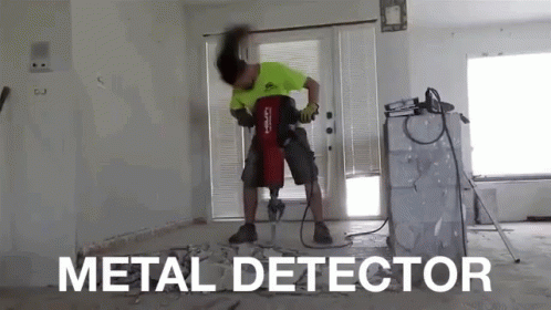 A Man Is Using A Metal Detector To Drill A Hole In A Wall GIF
