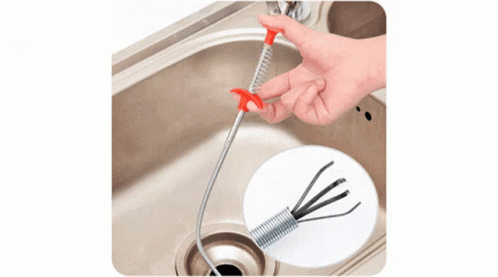 A Man Is Using A Milwaukee Drain Cleaner To Clear A Drain Under A Sink GIF