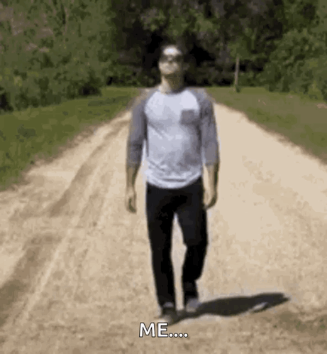 A Man Is Walking Down A Dirt Road With The Words `` Me '' Written On The Ground . GIF