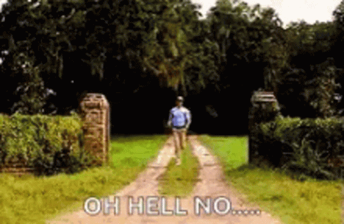 A Man Is Walking Down A Dirt Road With The Words `` Oh Hell No '' Written On The Ground . GIF