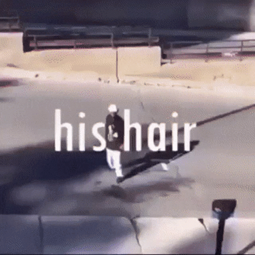 A Man Is Walking Down A Street With The Words His Hair Written Above Him GIF