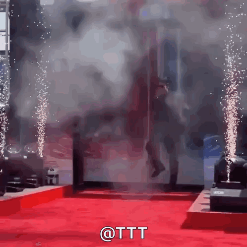 a man is walking on a red carpet with smoke coming out of the door