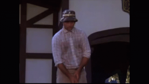 A Man Is Walking Through A Garden Of Flowers GIF