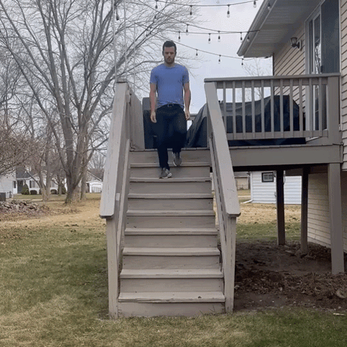 A Man Is Walking Up A Set Of Stairs GIF
