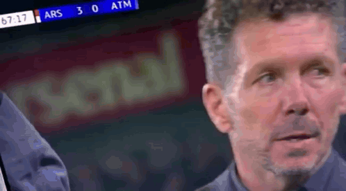 A Man Is Watching A Soccer Game On A Television . GIF