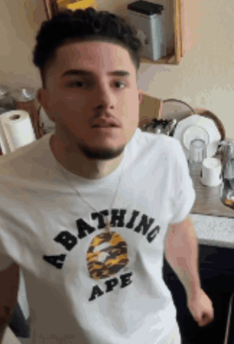 A Man Is Wearing A Bathing Ape Shirt GIF
