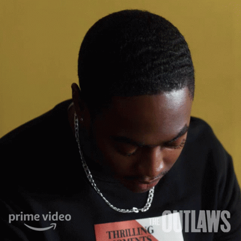 A Man Is Wearing A Black Shirt That Says The Outlaws On It GIF