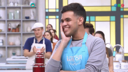 A Man Is Wearing A Blue Apron That Says Bake Off Argentina GIF