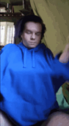 A Man Is Wearing A Blue Hoodie And Headphones GIF