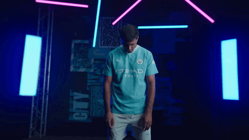 A Man Is Wearing A Blue Shirt That Says Etihad Airways GIF