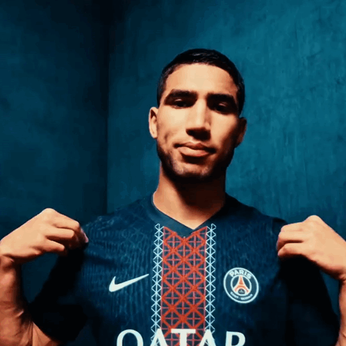 A Man Is Wearing A Blue Shirt With The Word Qatar On It GIF