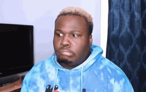 a man is wearing a blue tie dye hoodie and making a funny face .