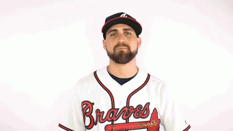 a man is wearing a braves jersey and a hat