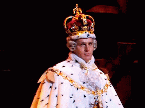 A Man Is Wearing A Crown And A White Robe . GIF