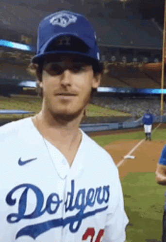A Man Is Wearing A Dodgers Jersey And Hat GIF