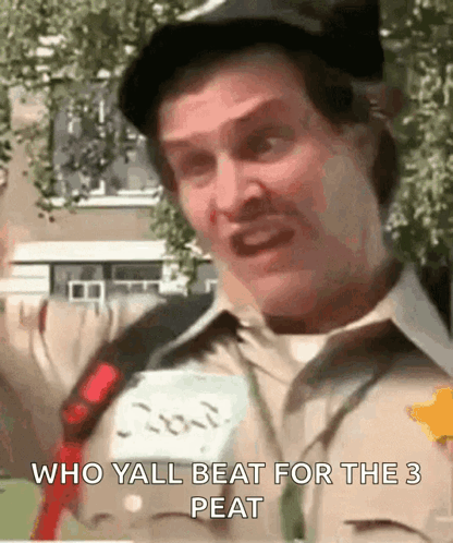 A Man Is Wearing A Hat And A Name Tag That Says " Who Yall Beat For The 3 Peat " . GIF