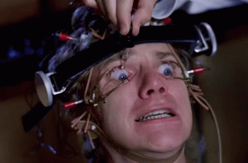 A Man Is Wearing A Helmet With Wires Coming Out Of It GIF