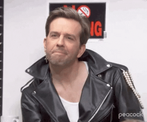 A Man Is Wearing A Leather Jacket And Earrings And Making A Funny Face . GIF
