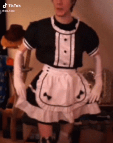 A Man Is Wearing A Maid Costume With Gloves And A Skirt . GIF