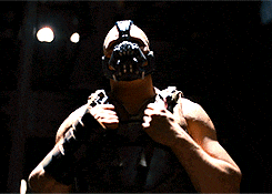 A Man Is Wearing A Mask And Holding A Gun GIF
