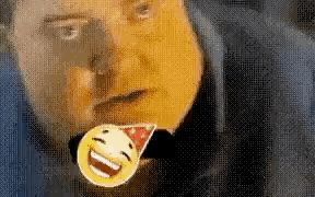 A Man Is Wearing A Party Hat And Holding A Smiley Face Pin In His Mouth . GIF