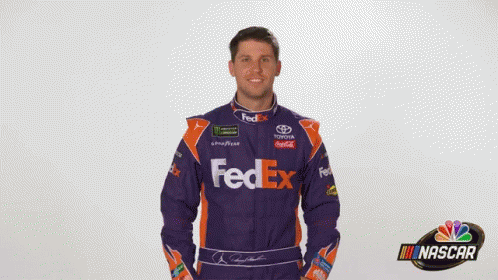 A Man Is Wearing A Purple And Orange Fedex Racing Suit GIF