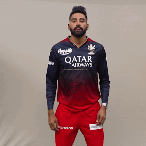 A Man Is Wearing A Qatar Airways Shirt And Red Pants GIF