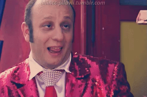 A Man Is Wearing A Red Sequined Jacket And Tie With A Tumblr.com Watermark GIF