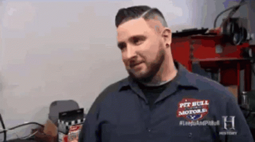 A Man Is Wearing A Shirt That Says Pit Bull Motors GIF