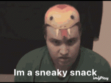 A Man Is Wearing A Snake Mask On His Head And Says I 'M A Sneaky Snack GIF