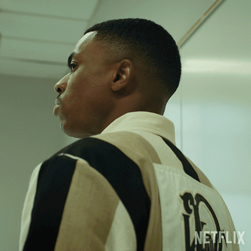 A Man Is Wearing A Striped Shirt With A Netflix Logo On The Back GIF