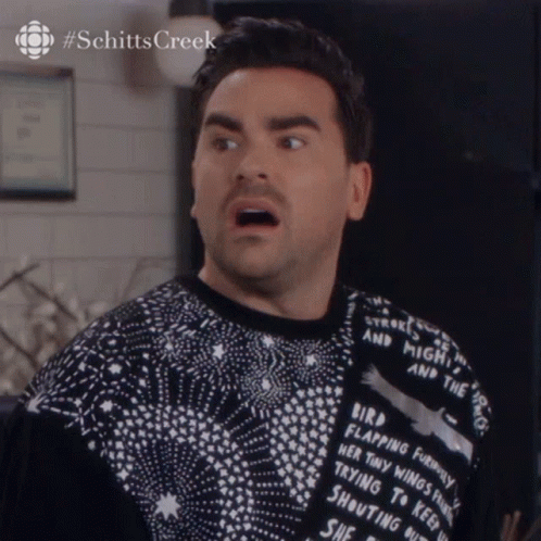 A Man Is Wearing A Sweater That Says " Bird Flapping Feathers " On The Back GIF