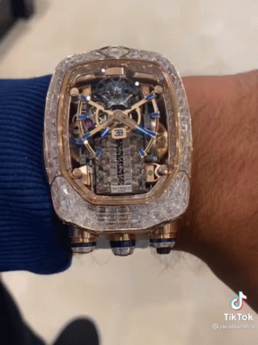 A Man Is Wearing A Watch That Has A Bugatti Logo On It GIF